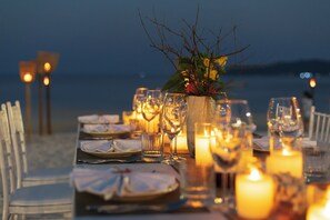 A table set for a meal with candles and glassware, overlooking a body of water. - La passion by Achariyak (Koh Rong Sanloem)