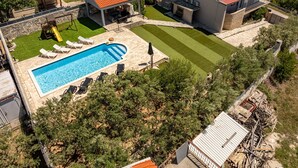 A residential property with a swimming pool, a covered patio, and a well-maintained lawn. - Villa Elder (Benkovac)