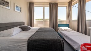 A hotel room with two beds, a large window with curtains, a headboard, and framed pictures on the wall. - Villa Elder (Benkovac)