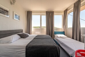 A hotel room with two beds, a large window with curtains, a headboard, and framed pictures on the wall. - Villa Elder (Benkovac)