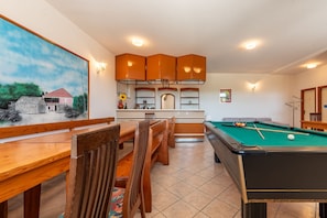 A pool table with a green felt surface, wooden chairs, and a dining table with chairs. - Villa Elder (Benkovac)