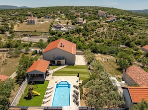A residential area with a large house featuring a swimming pool, a patio, and a playground. - Villa Elder (Benkovac)