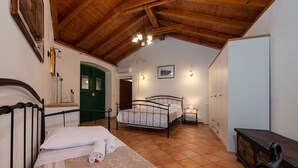 A bedroom with two beds, wooden ceiling beams, a green door, and a white wardrobe. - Villa Oak (Benkovac)
