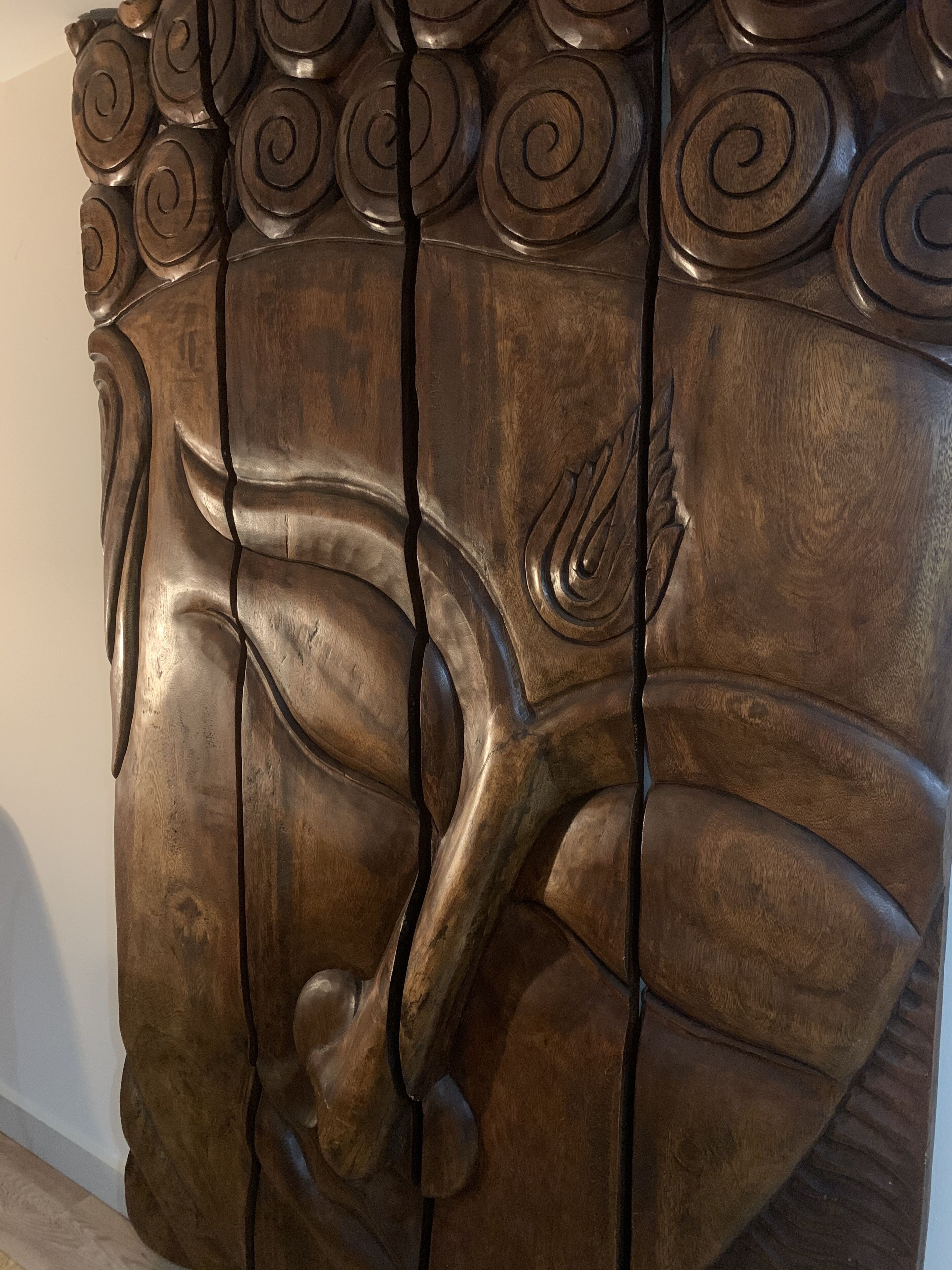 A detailed wooden sculpture with a horse and rider, featuring intricate carvings and a polished finish.