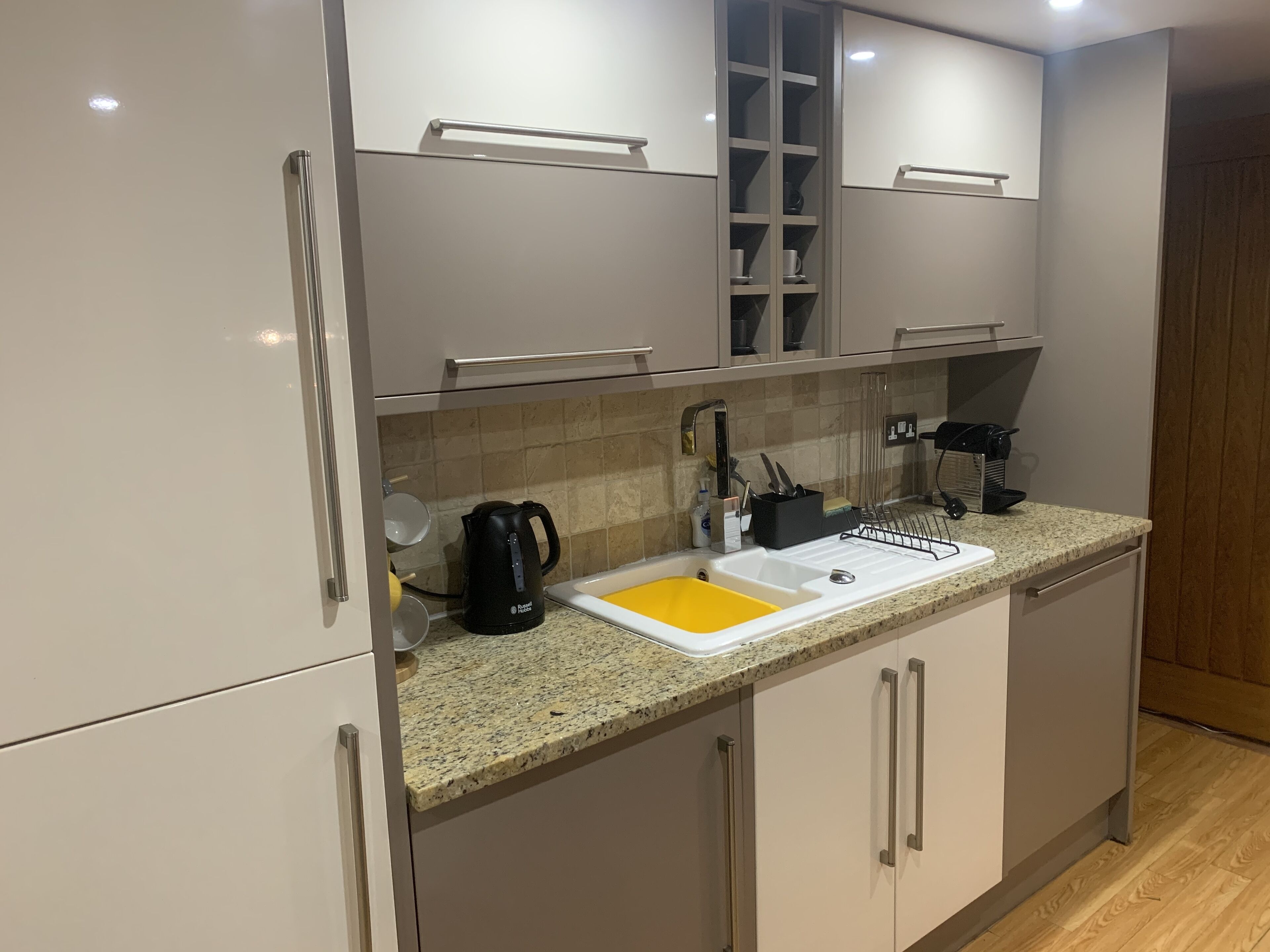 Una cocina moderna con encimera de granito, un fregadero y electrodomésticos de acero inoxidable.
