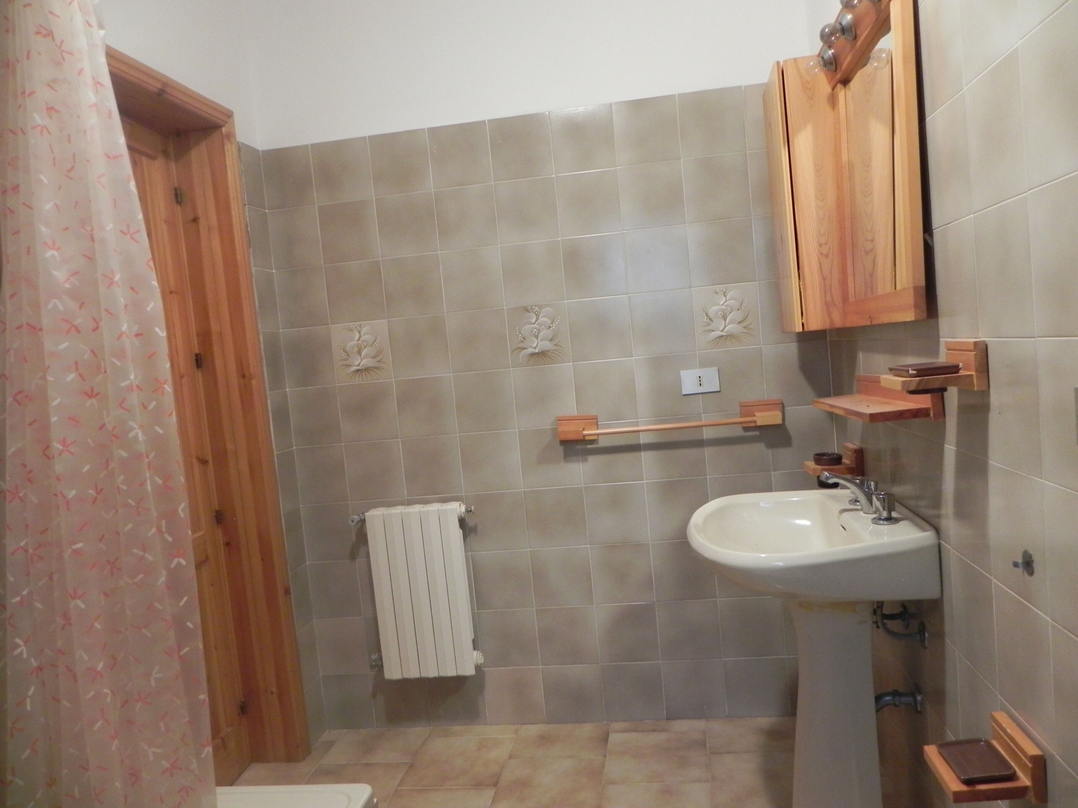 Une salle de bain avec un lavabo, des meubles en bois, un porte-serviettes et des toilettes.