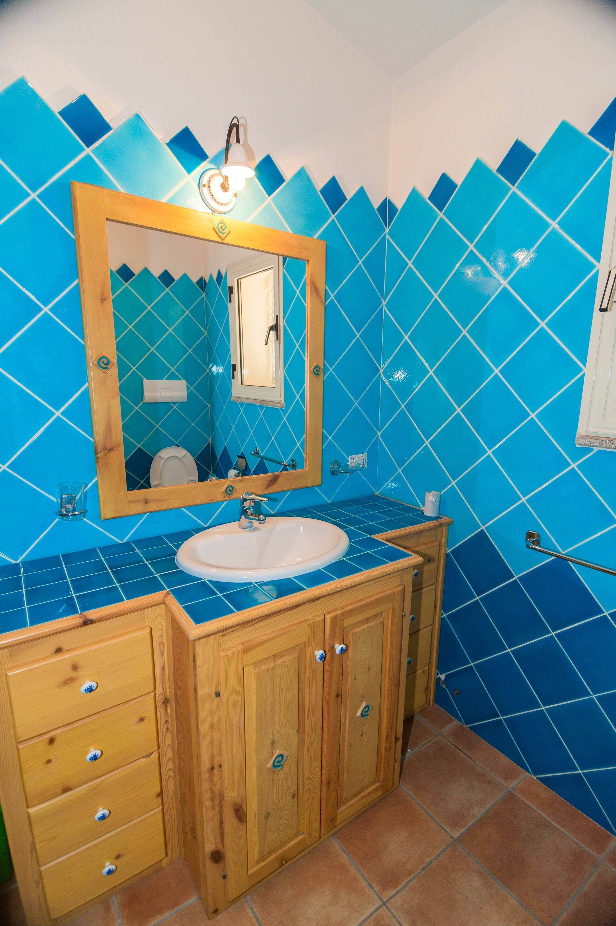 A bathroom with a wooden vanity, a sink, and a mirror.