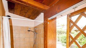 A shower area with tiled walls and a wooden ceiling. - Fantastic Sardinia Casa Podas pod01 (Budoni)