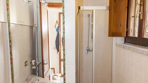 A bathroom with a sink, mirror, shower, and cabinets. - Fantastic Sardinia Casa Castas cast01 (Budoni)