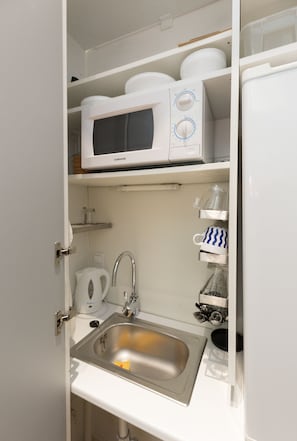 Departamento | Cocineta privada | Refrigerador con congelador, microondas y utensilios de cocina