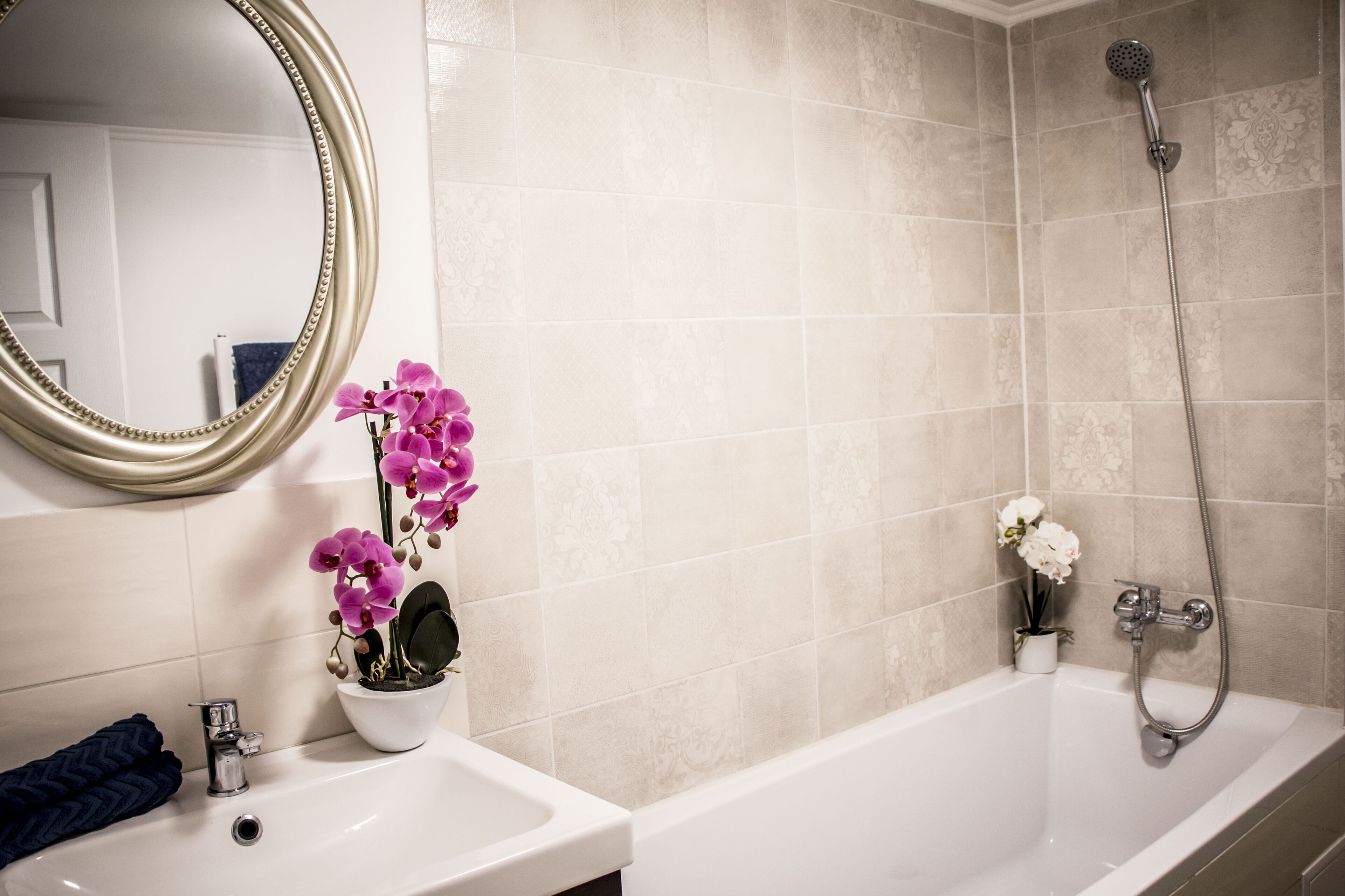 Ein Badezimmer mit Badewanne, Waschbecken, Spiegel und Dusche.