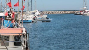 A marina with several boats docked, a rocky breakwater, and a clear blue sky. - Comfy Apartment in Kröpelin near Sea Beach (Kroepelin)