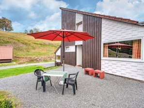 Relax on the patio with a table for two, a comfortable bench, and a shaded area.