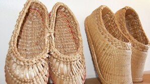 A pair of woven slippers and a single woven shoe on a wooden surface. - Gorgeous Holiday Home in Roussines With Terrace (Roussines)