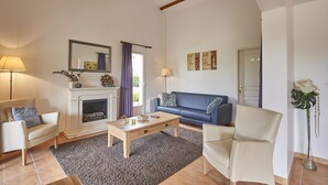 A living room with a fireplace, a sofa, a coffee table, and a lamp.