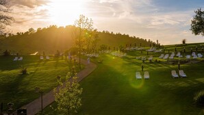 A golf course with neatly arranged white lounge chairs and a pathway.