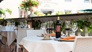 A table set for dining with a bottle of wine, glasses, and a plate of food.