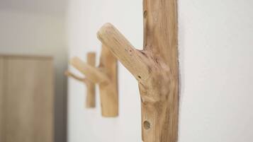 Ein an der Wand befestigter, hölzerner Haken mit natürlicher Holzoptik.