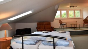 A bedroom with a bed, a nightstand, a lamp, a chair, a small table, and a radiator. - Expansive Holiday Home in Mecklenburg near Baltic Sea (Walkendorf)