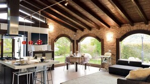 Una cocina amplia con una isla central, comedor y una zona de estar acogedora con vistas al exterior.