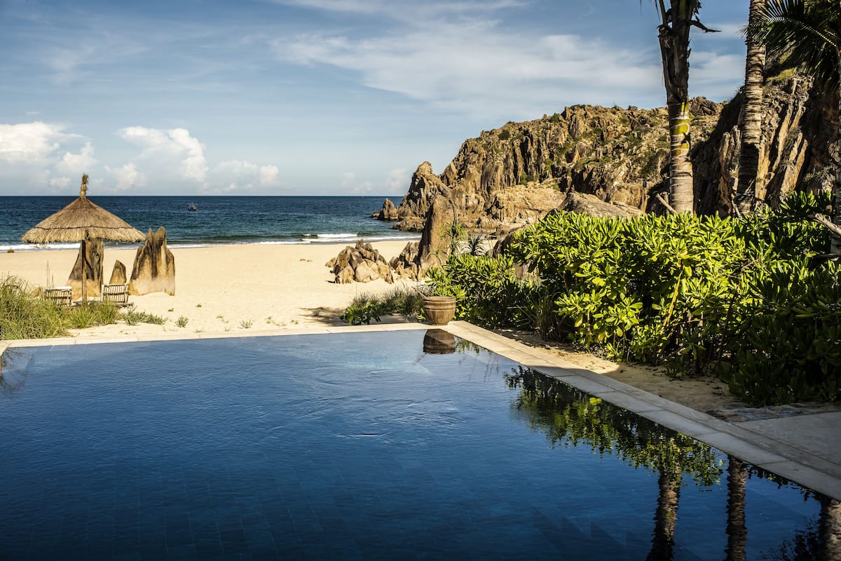 Ein Pool mit Blick auf den Strand und die Felsen.