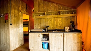 A rustic kitchen with wooden cabinets, a sink, and a coffee maker. - Apartment in Netherlands Near Nature Trails (Udenhout)