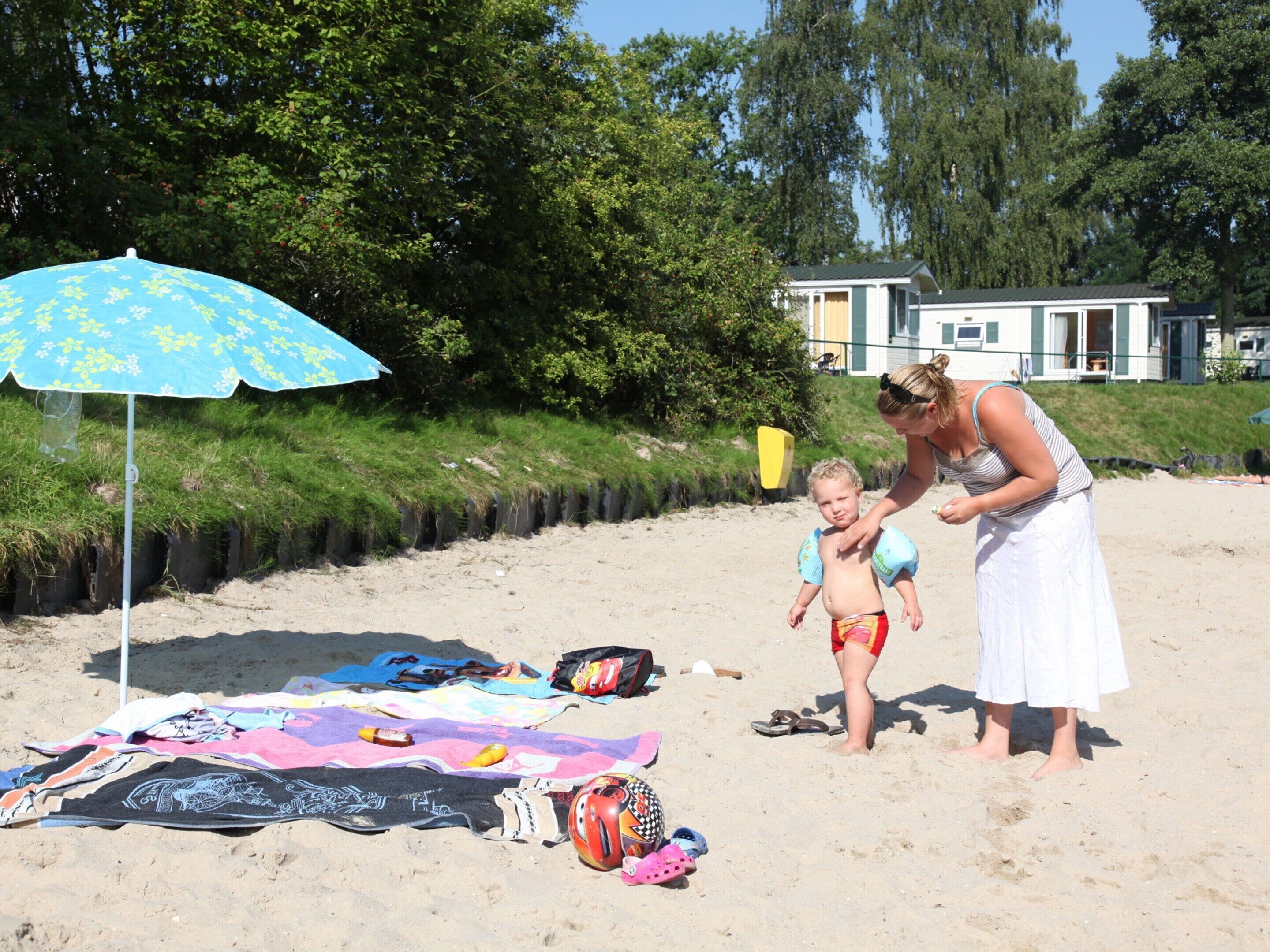 Escena de playa con un niño y un adulto.