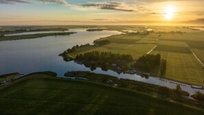 An aerial view of a river with surrounding fields and a small settlement. - Modern Chalet Near Lake Sneek (Terkaple)