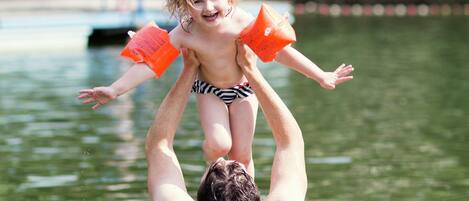 A man holding a child above water.