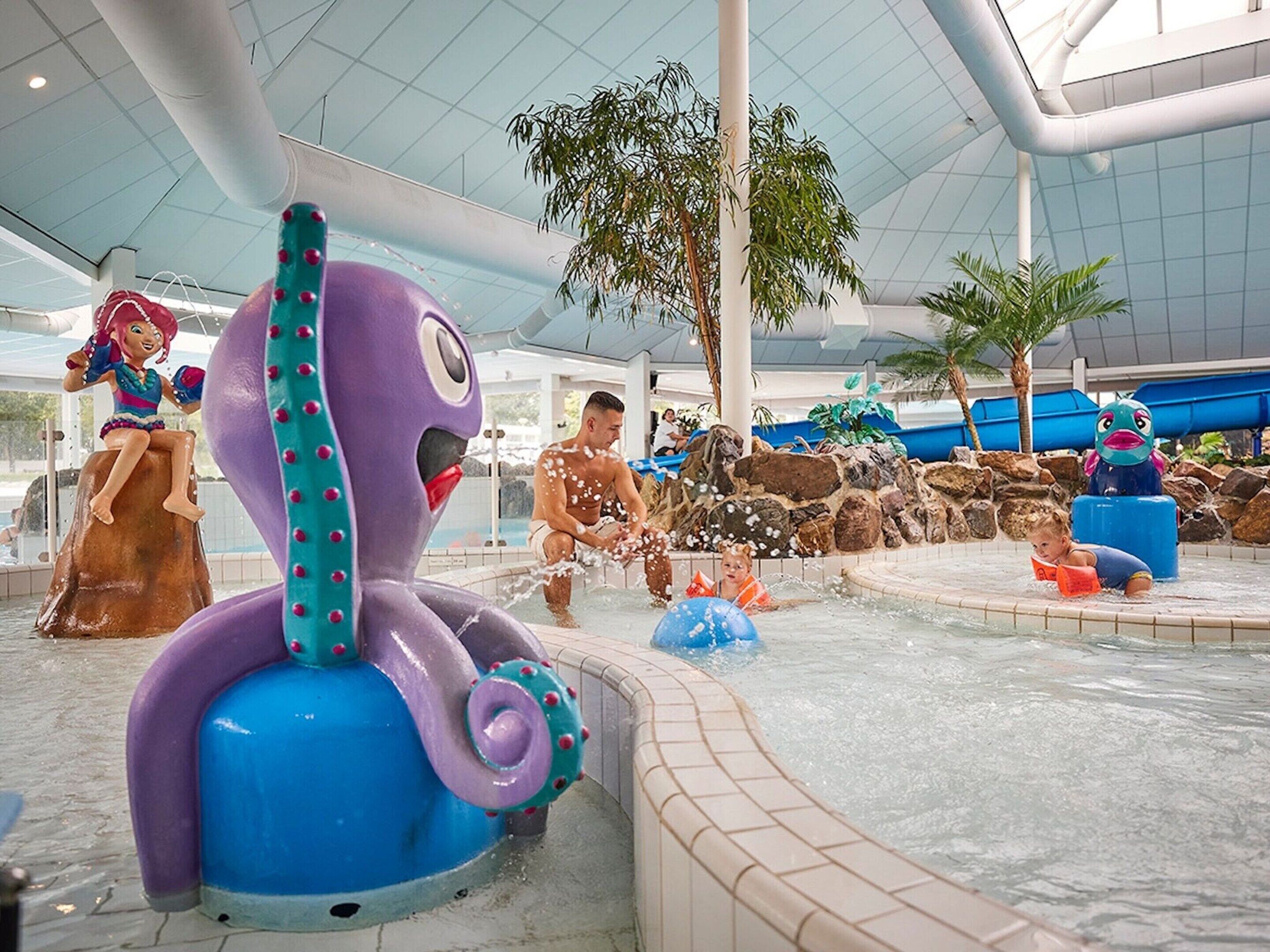 A water play area with a large octopus sculpture, a slide, and a pool.