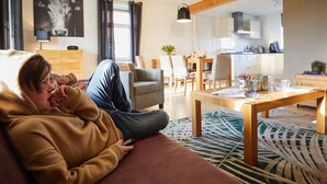 Un salon moderne avec un canapé, une table basse et, au fond, un coin repas.