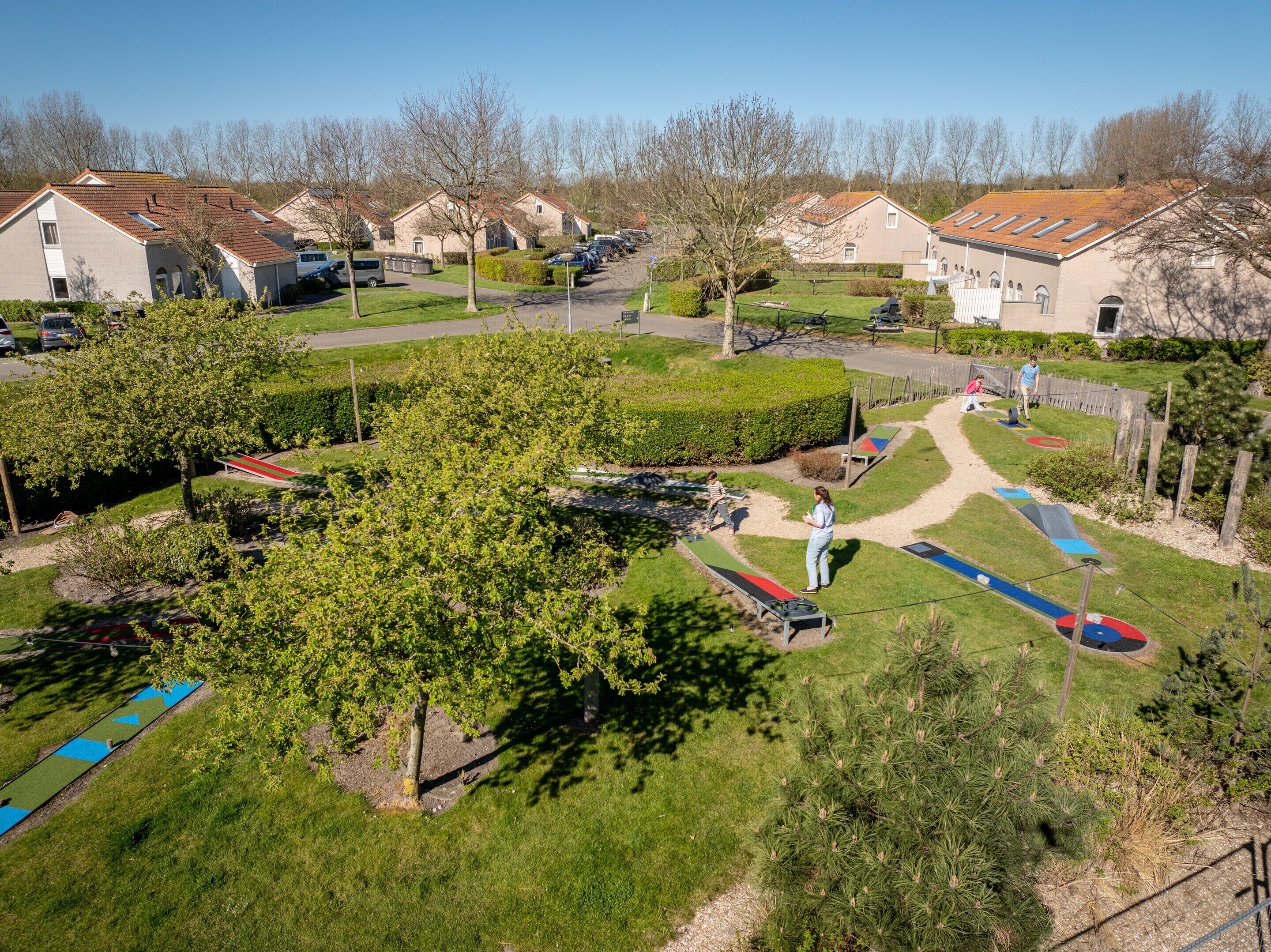 A residential area with houses, a playground, and a clear sky.