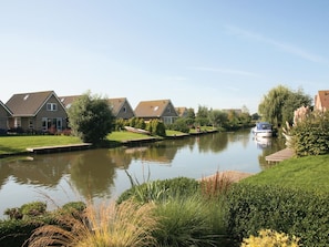 A canal with houses on one side and a boat docked on the other.