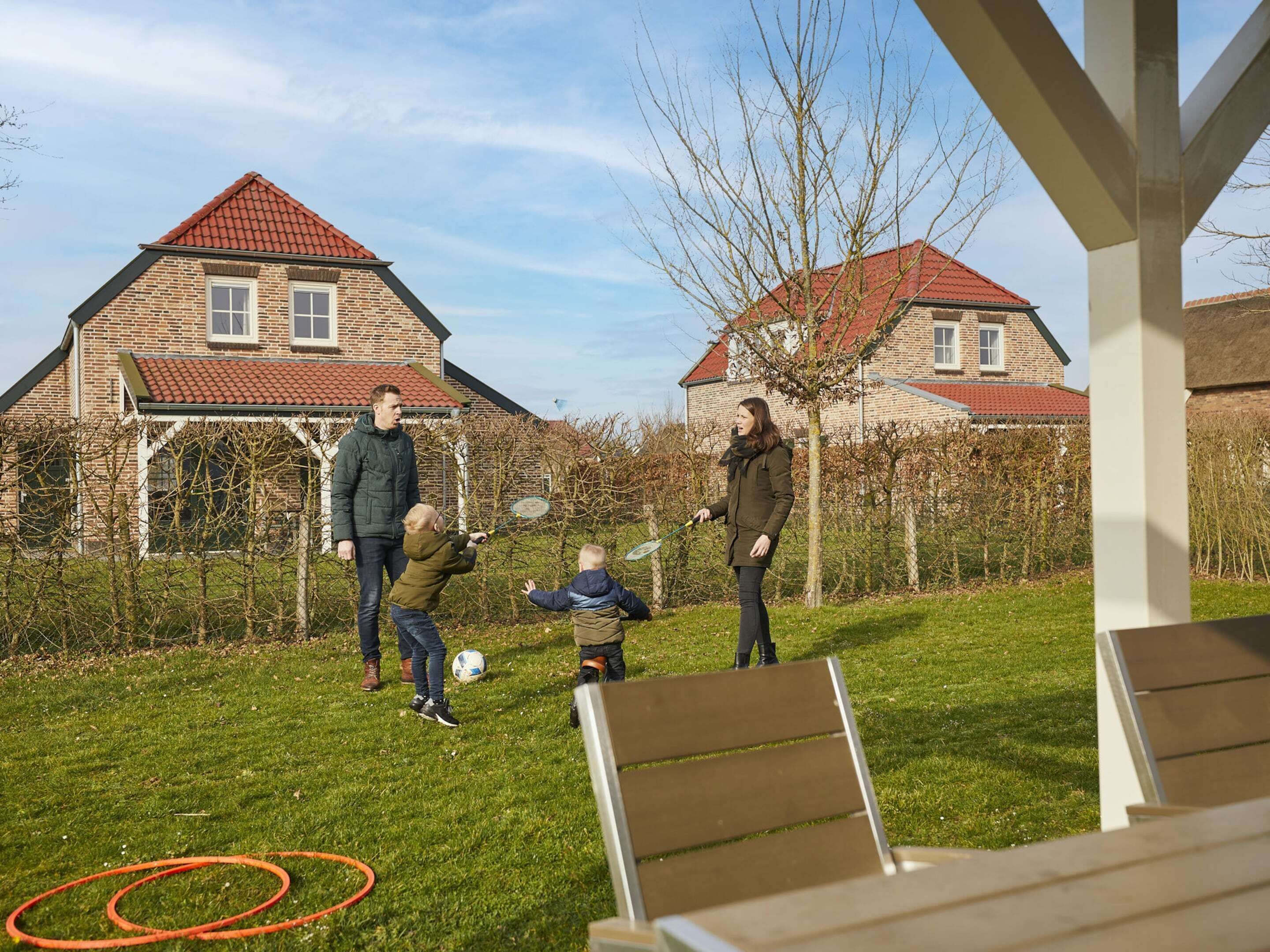 A residential area with brick houses, a grassy yard, and a wooden bench.