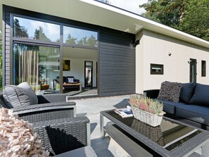 A modern outdoor living space with a sofa, chairs, and a coffee table.