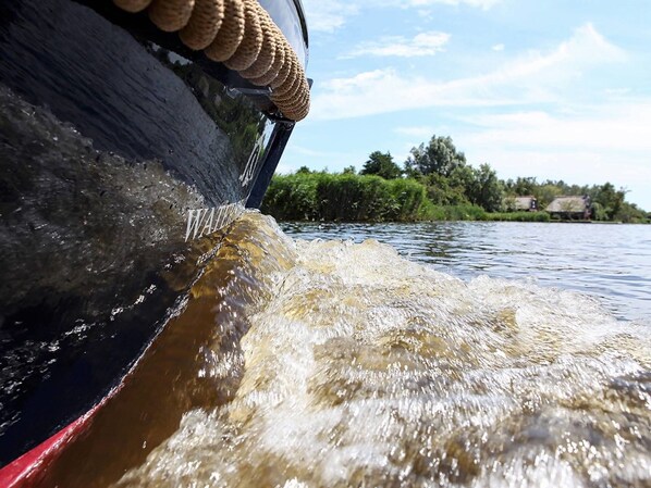 A boat with a water spout and a rope decoration.