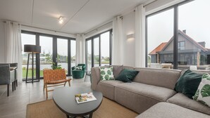En moderne stue med sofa, sofabord og udsigt ud