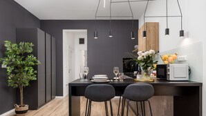 A modern kitchen with a central island, bar stools, and pendant lighting. - Saint Vitus Apartments with balcony (Rijeka)