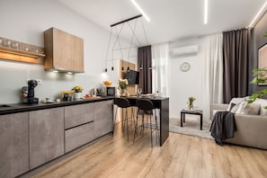 Une cuisine moderne dotée d’un îlot central, de tabourets de bar et d’un coin repas.