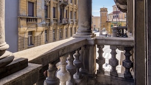 A balcony with stone balustrades overlooking a street with historic buildings. - Saint Vitus Apartments with balcony (Rijeka)