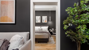 A modern bedroom with a bed, bedside table, and a desk with a chair. - Saint Vitus Apartments with balcony (Rijeka)