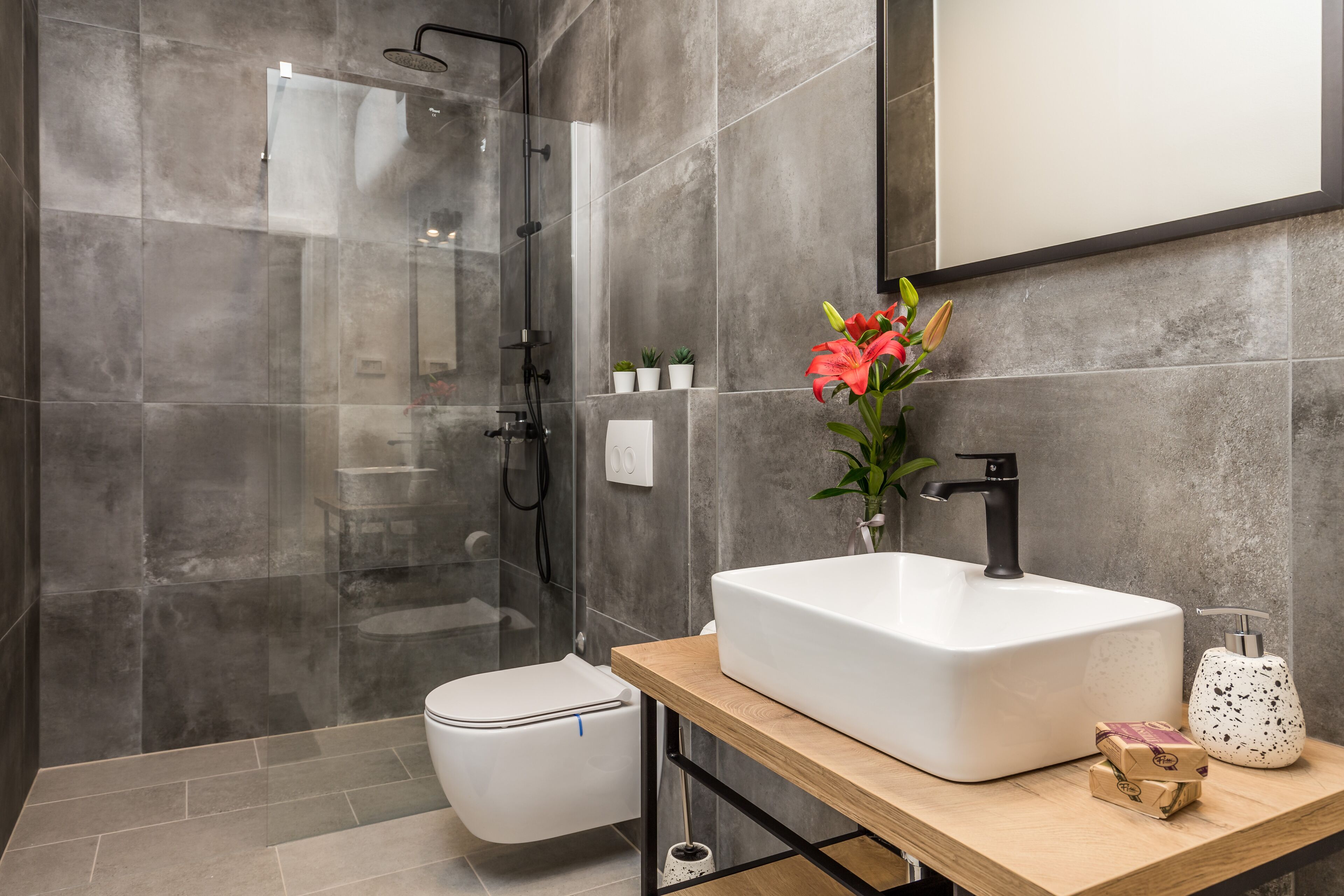 A modern bathroom with a shower, toilet, and sink.