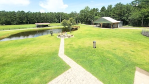 A well-maintained grassy area with a pond, picnic tables, and a covered pavilion. - Welcome to Riptide Stables, 17 Acre Farm, w/animals by the beach! (Castle Hayne)