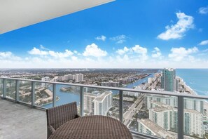 Un balcón con vistas a la ciudad costera, incluyendo un río y edificios altos.