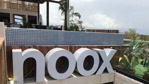A building with a large sign spelling "noox" and a tiled roof. - noox Tulum (Tulum)