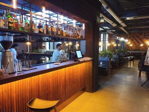 A bar area with a wooden counter, bar stools, and a variety of bottles and glasses. - Araks Hotel Complex (Gyumri)