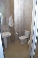 Ein Badezimmer mit Waschbecken, Toilette und einem Handtuch an der Wand.