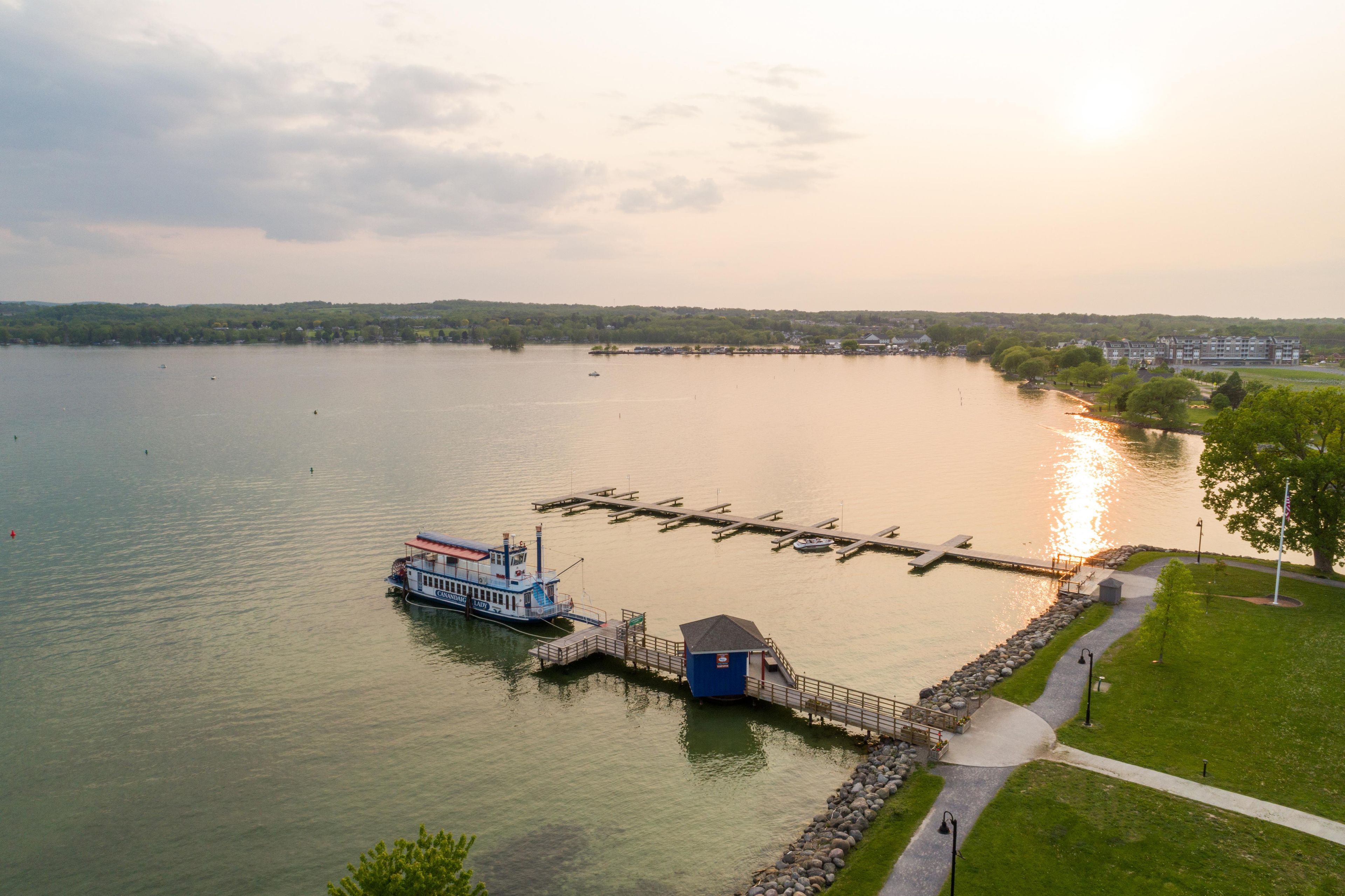 A lake with a dock, a boat, and a small building.