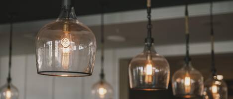A series of pendant lights with a clear glass shade and visible filament bulbs.
