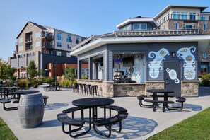 A waterfront restaurant with outdoor seating, stone walls, and nautical-themed decor. - Hotel Canandaigua, Tapestry Collection by Hilton (Canandaigua)